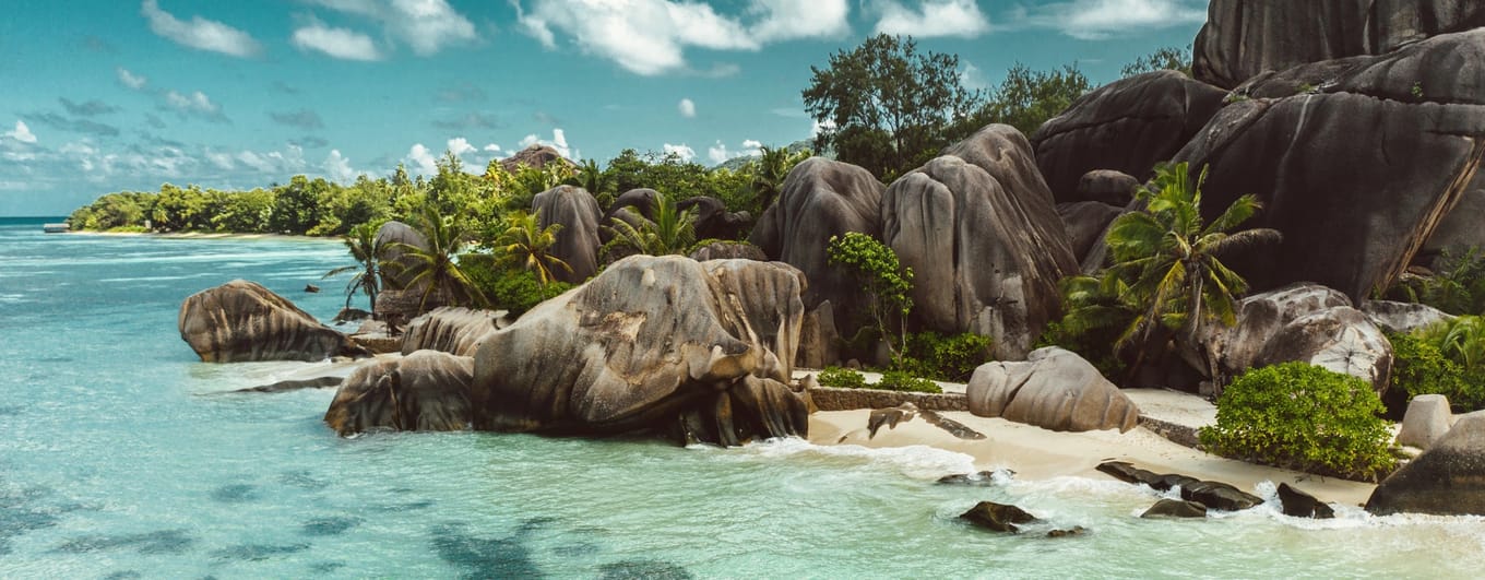 Boulders on a white sandy beach with crystal clear water in the Seychelles