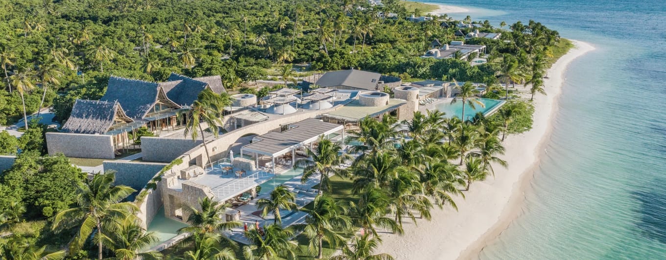 Luxury villa beside white sand beach with palm trees