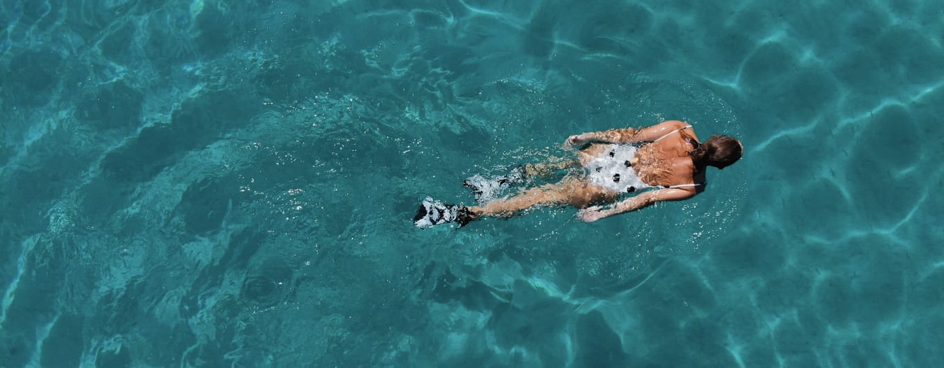 Aerial view of lady swimming in the sea