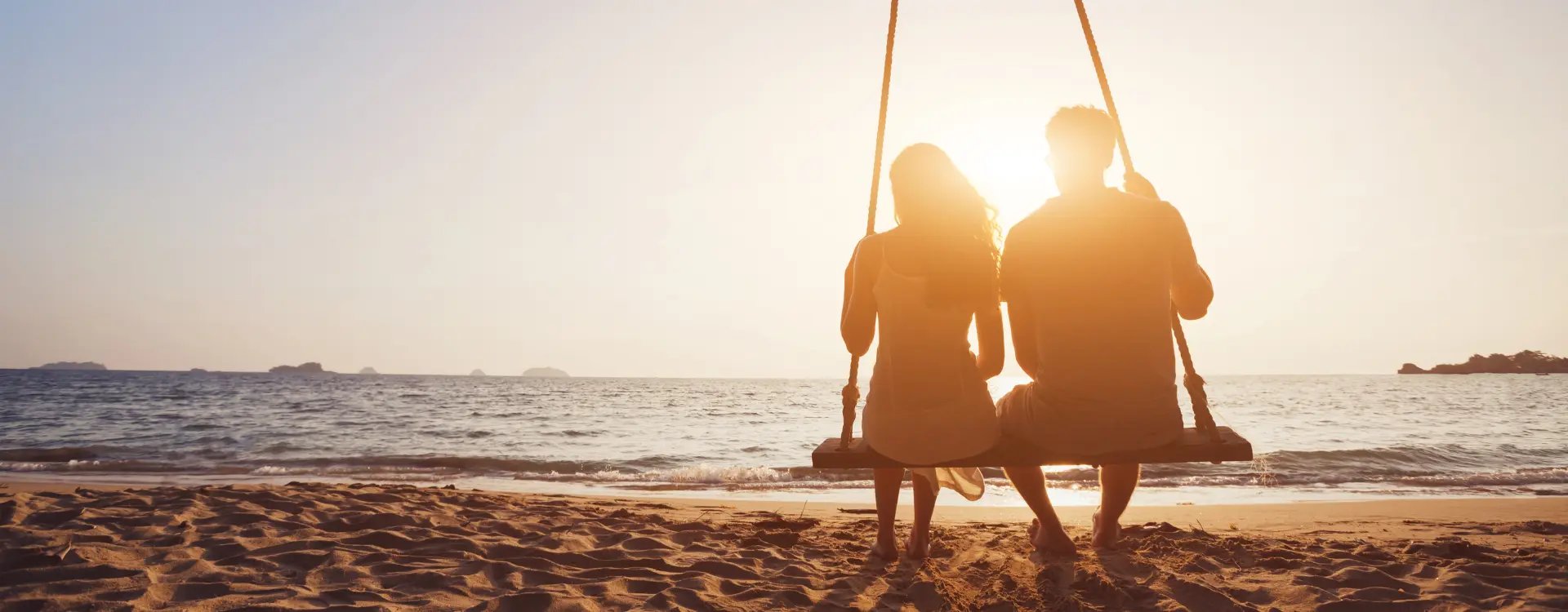 Couple on a swing looking out at the sea