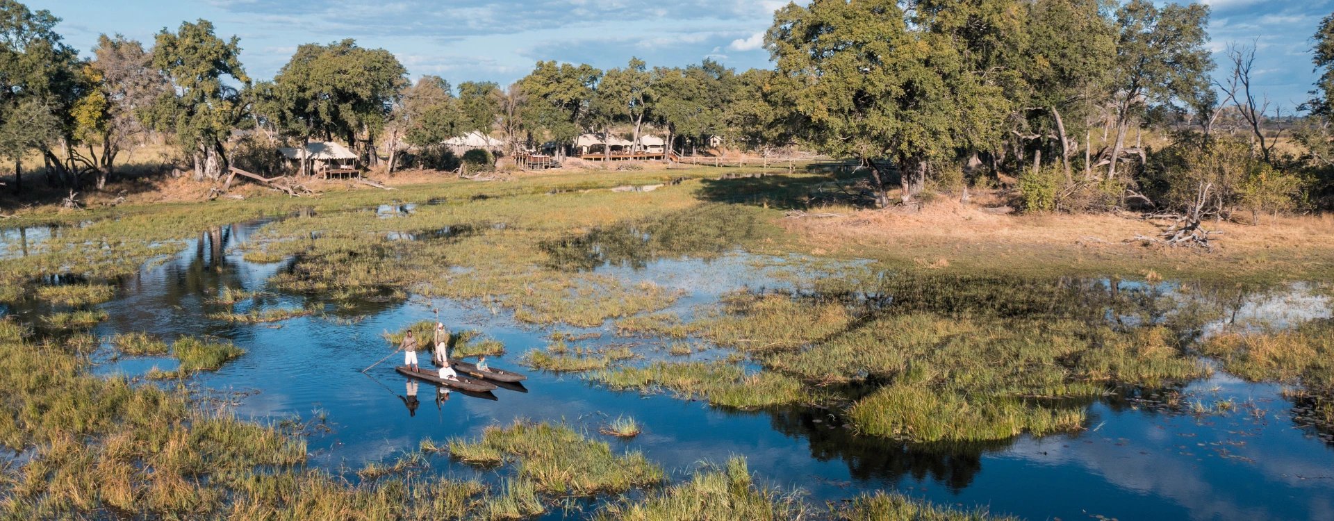 Aerial view of the Okavango Delta waterways with a luxury lodge on the river bank