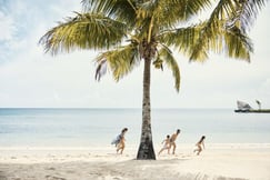 family on a beach at como laucala island