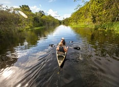 canoeing along amazon river in peru