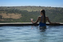 Private swimming pool with lady drinking cocktail overlooking valley