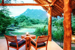 Table and chairs overlooking pool and Monkey Mountain at Gal Oya Lodge