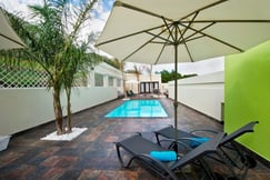 Swimming pool with sunloungers and umbrella