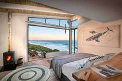 Ocean views from bedroom at sunset with wood burning fire