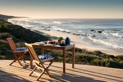 Table and chairs on outdoor deck overlooking private beach with views of the Indian Ocean