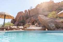 Swimming pool with lady reading book on sunlounger