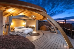 Bedroom at dusk with double bed and views of surrounding landscape