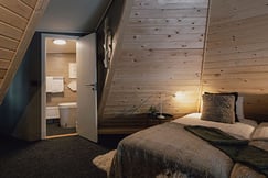 Bed and bathroom interior at Aurora Safari Camp Sweden