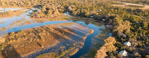 Aerial view of river delta in Africa with luxury camp