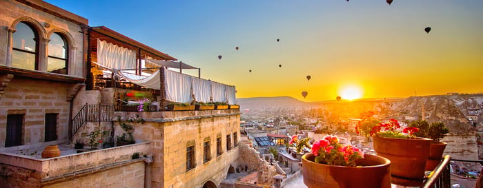 Hot air balloon at sunrise over mountains, Goreme, Cappadocia.