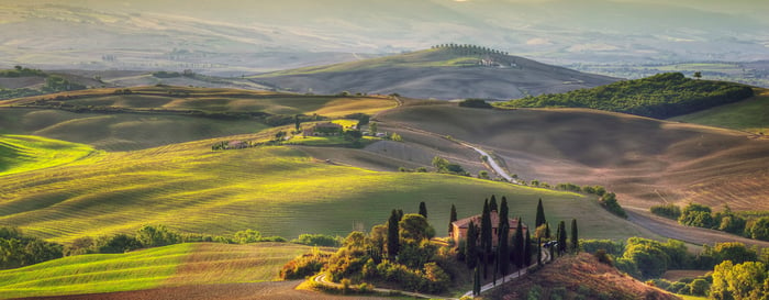 Tuscany landscape at sunrise. Typical for the region tuscan farm house, hills, vineyard. Italy