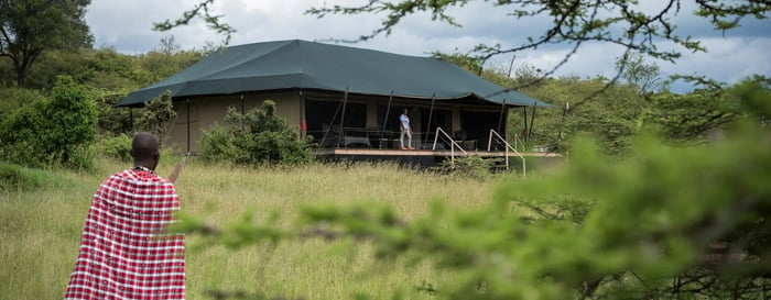A Masai Guide in Kenya approaching a luxury lodge